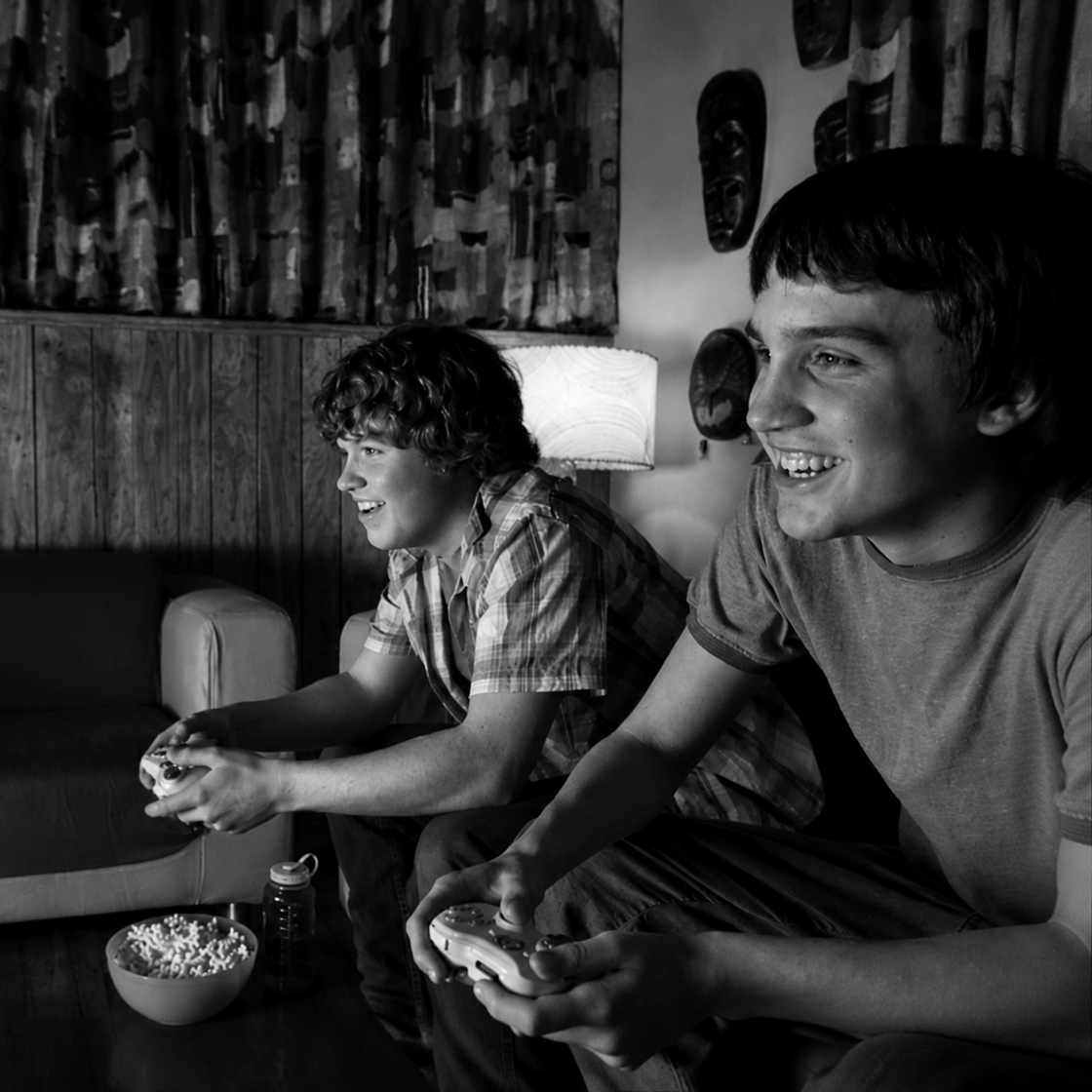 Schwarz-Weiß-Bild „Our Story“ mit zwei Freunden beim Spielen mit Controllern im Wohnzimmer als Symbol gemeinsamer Retro-Gaming-Erinnerungen.