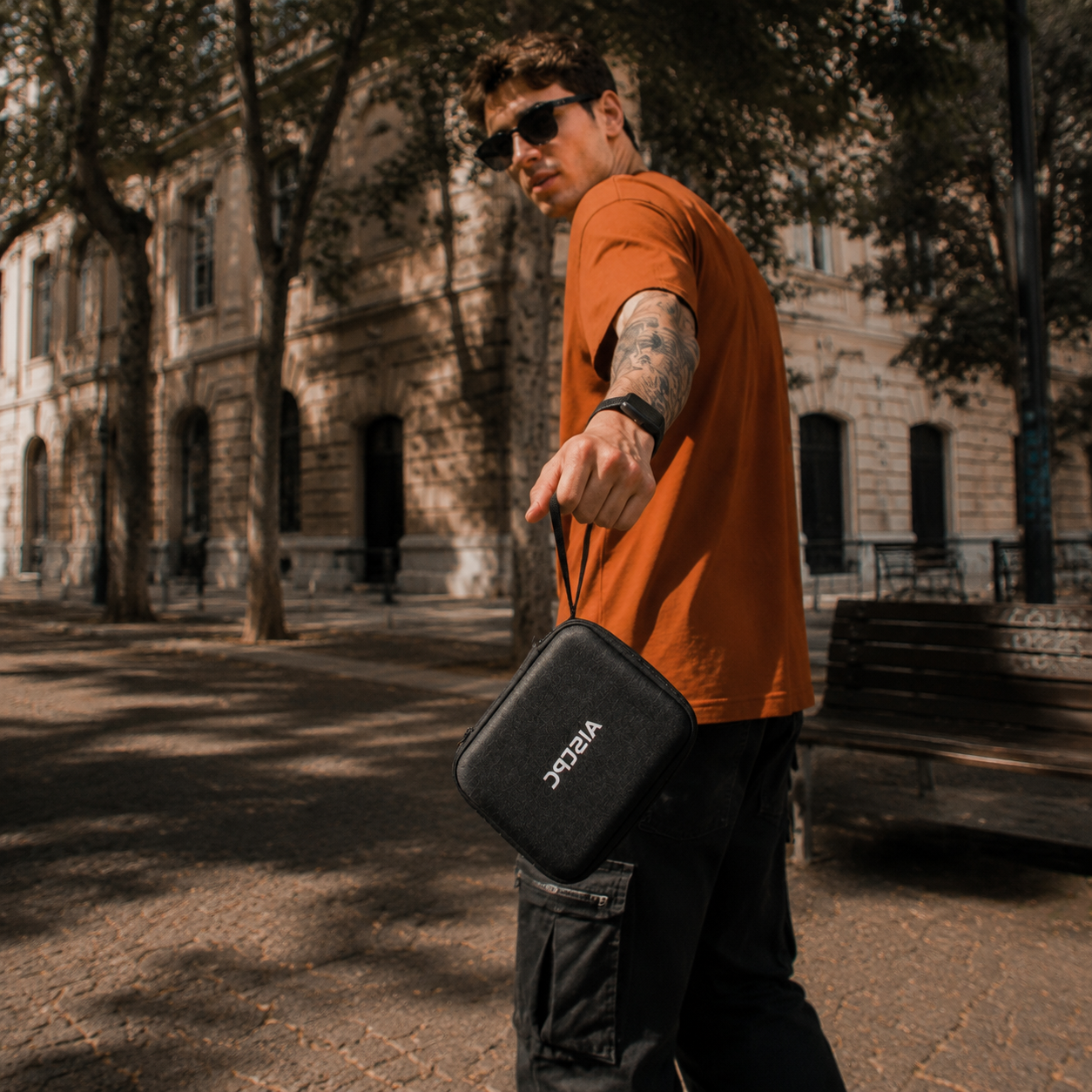 A man carrying an AISLPC handheld console carrying case outdoors, showing the portable storage case for RG52 MINI and RG52 PRO MAX.